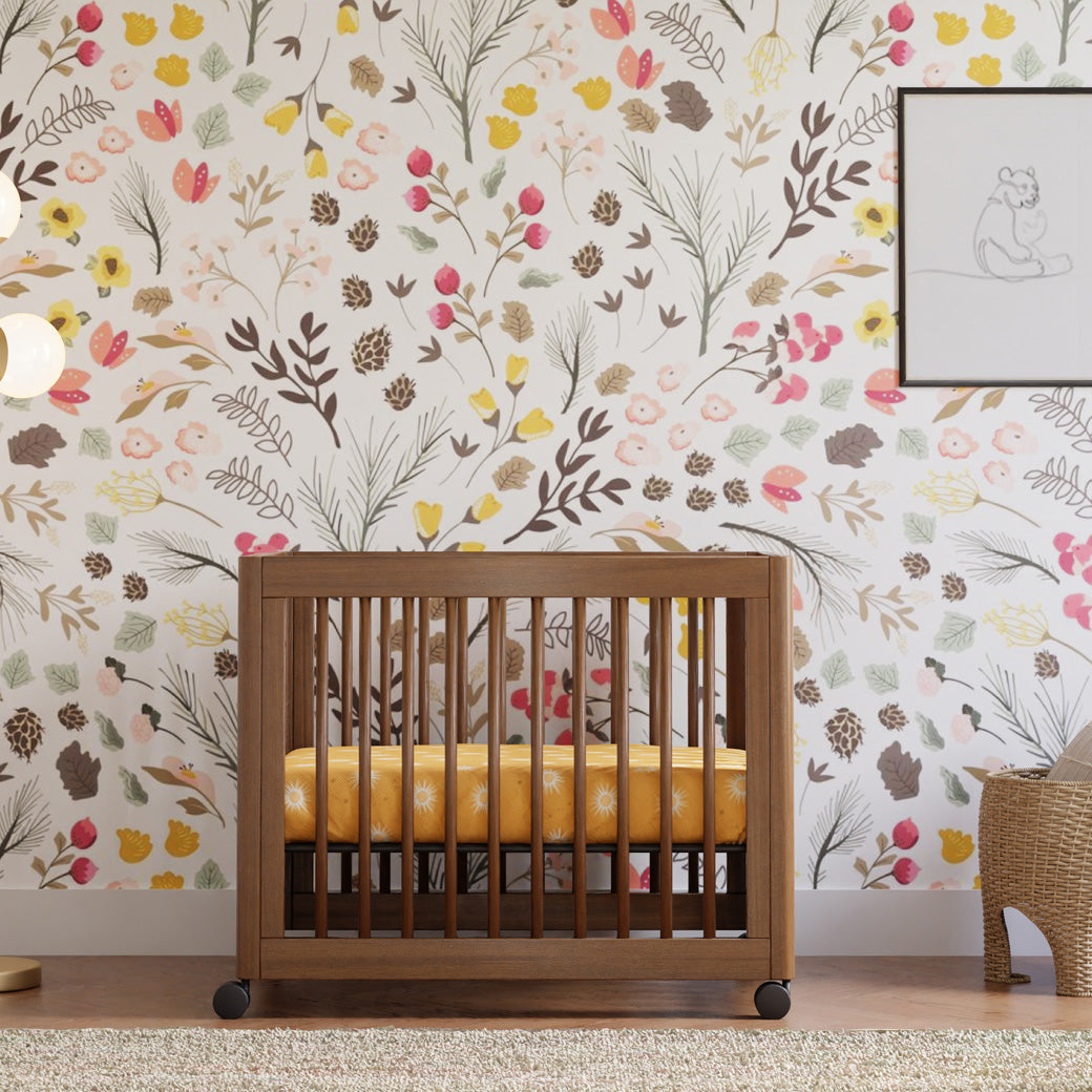 Babyletto's Yuzu 8-In-1 Convertible Crib in a floral room  in -- Color_Natural Walnut