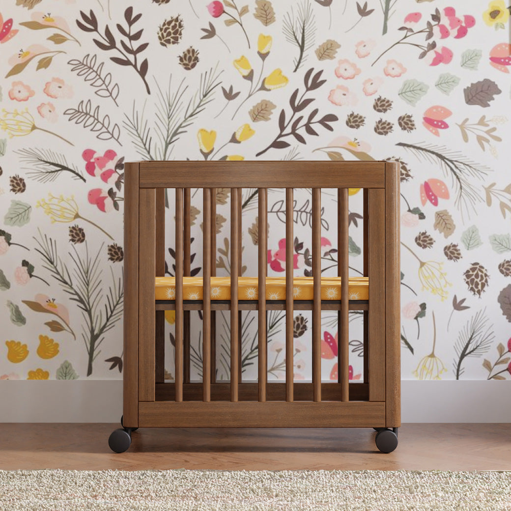 Babyletto's Yuzu 8-In-1 Convertible Crib in a colorful room  in -- Color_Natural Walnut