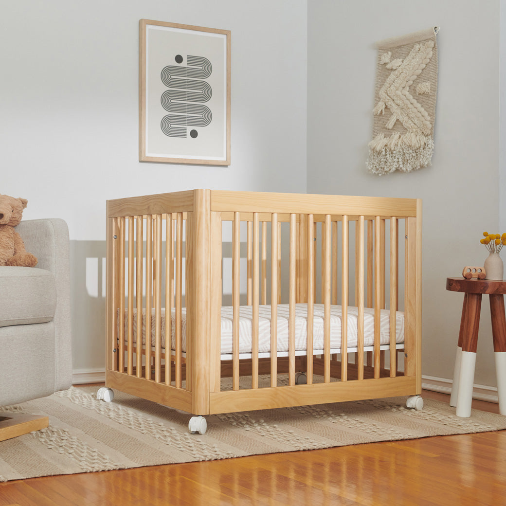 Babyletto's Yuzu 8-In-1 Convertible Crib in a baby room next to a recliner in -- Color_Natural