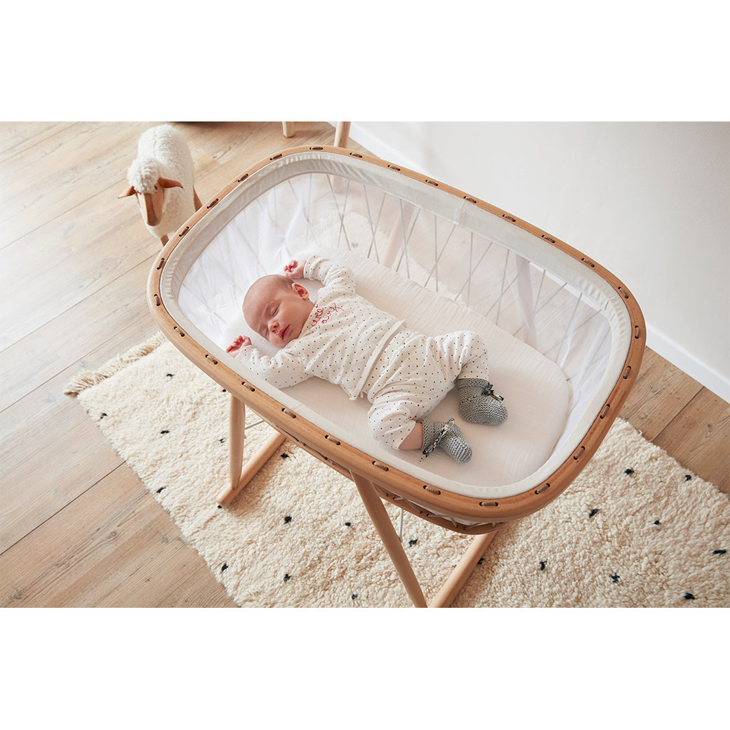 Overhead view of a baby sleeping in Charlie Crane KUMI Cradle in -- Color_Hazelnut