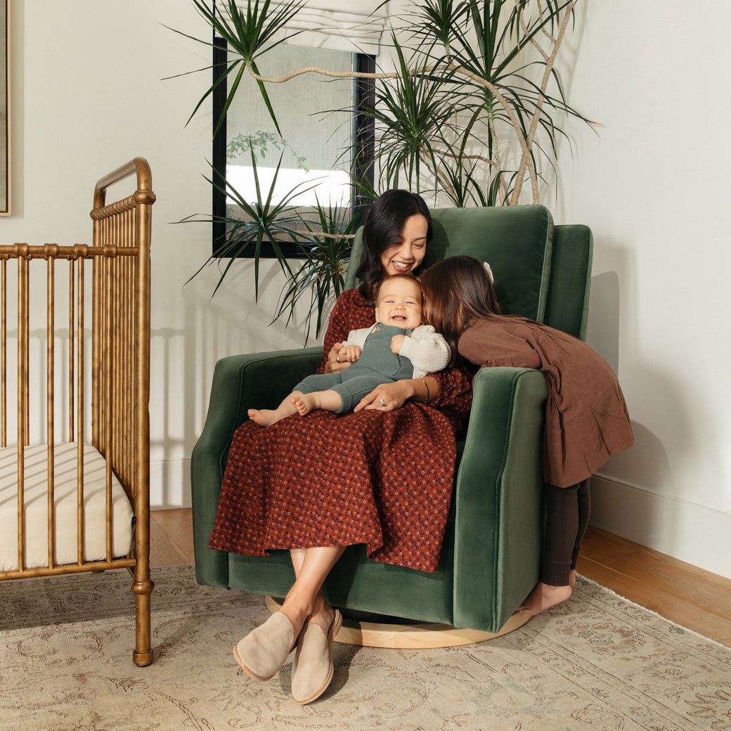 Mother with children sitting in Crewe Recliner & Swivel Glider in -- Color_Forest Green Velvet With Light Wood Base