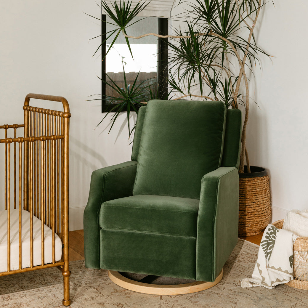 Crewe Recliner & Swivel Glider next to a crib  in -- Color_Forest Green Velvet With Light Wood Base