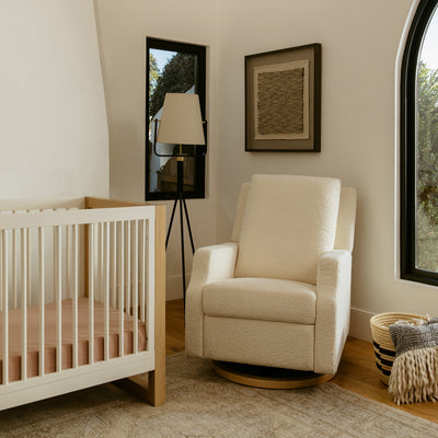 Namesake's Crewe Recliner & Swivel Glider in a room next to a crib and window in -- Color_Ivory Boucle With Light Wood Base