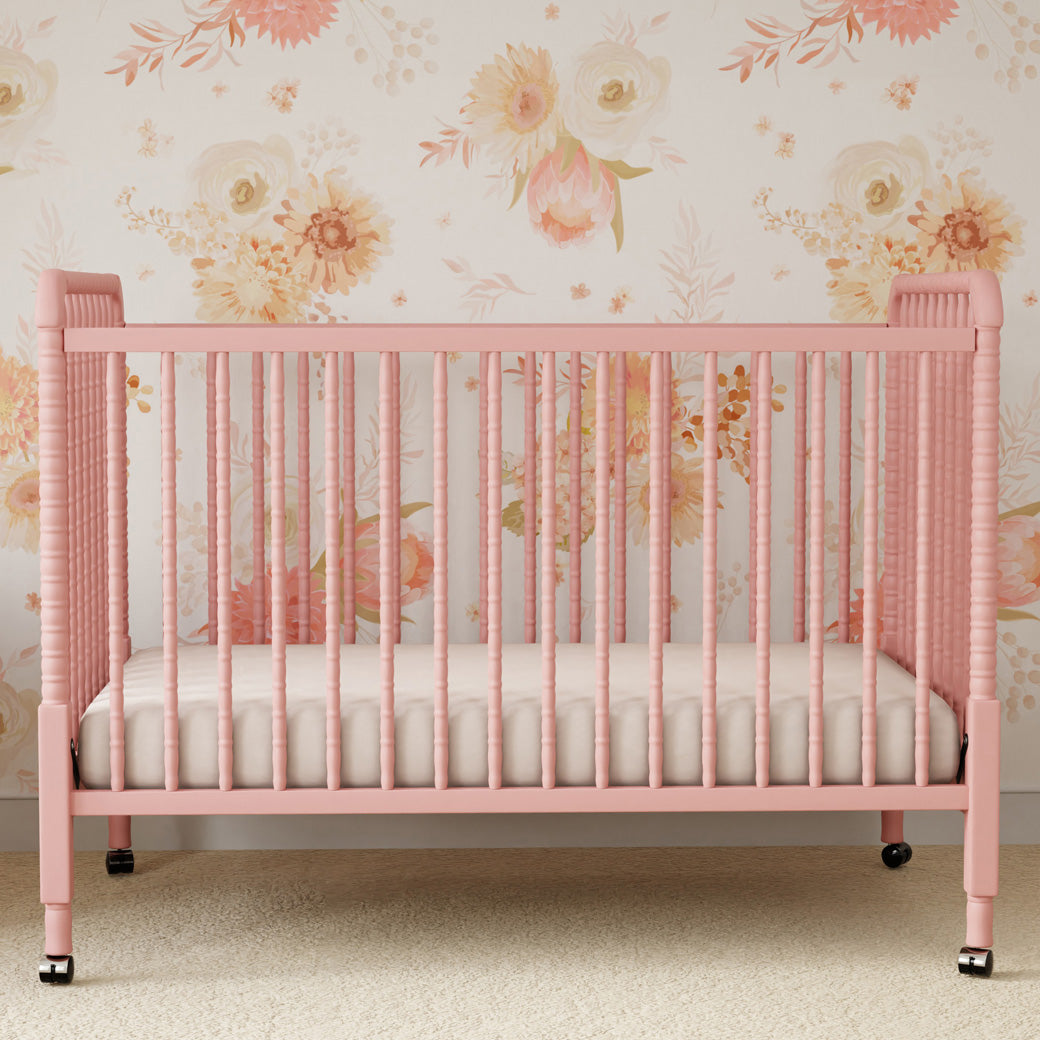 Lifestyle front view of the DaVinci’s Jenny Lind Crib in a floral room in -- Color_Blush Pink