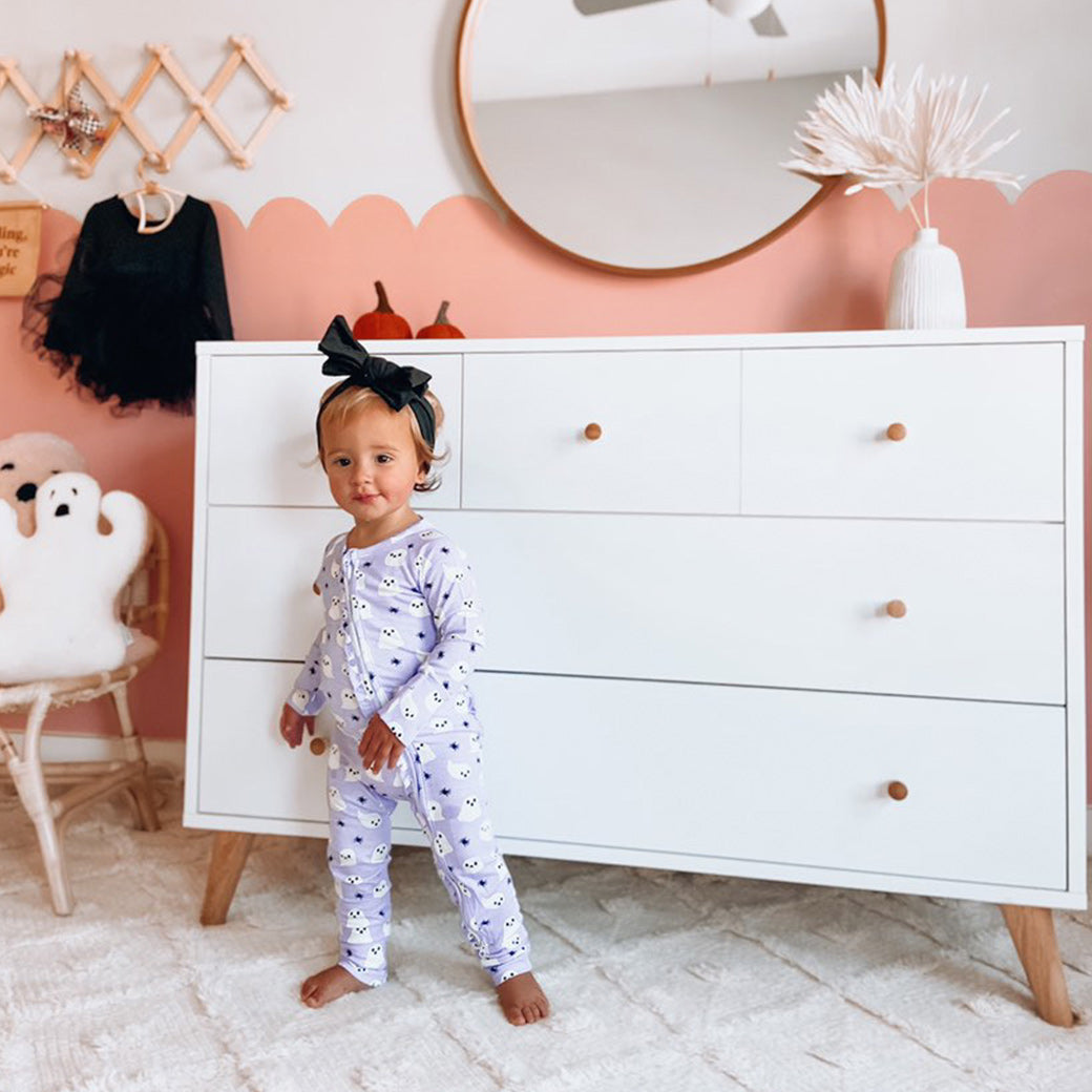 A toddler in front of the Dadada Austin 5-Drawer Dresser in -- Color_White/Natural