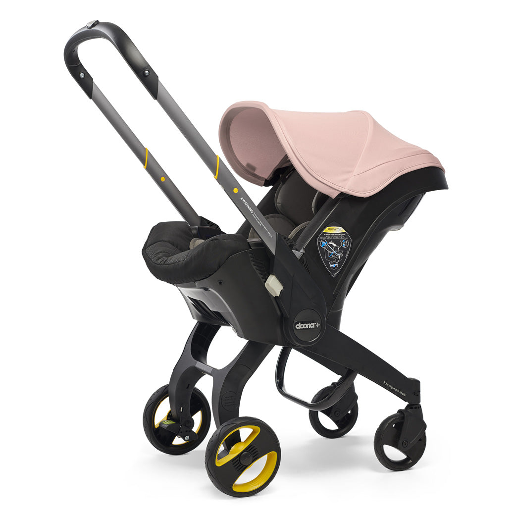 Side view of Doona Infant Car Seat and Stroller in -- Color_Blush Pink