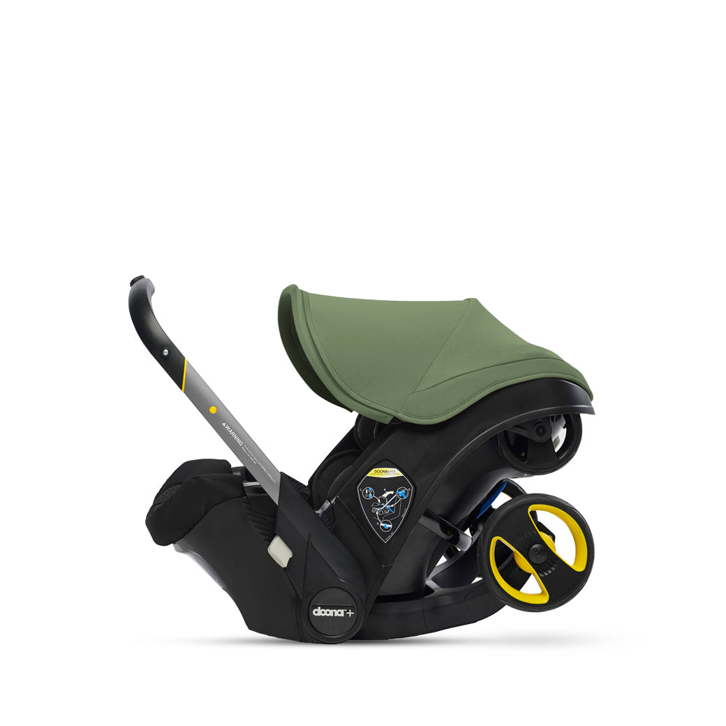 Folded up profile view of Doona Infant Car Seat and Stroller in -- Color_Desert Green