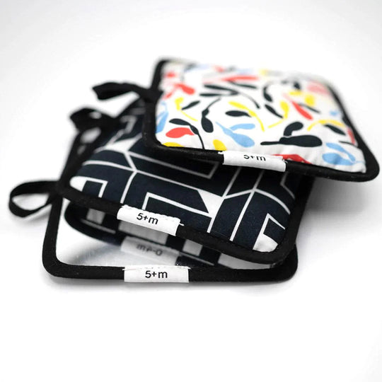 Side view of pilled up Etta Loves Sensory Hanging Squares in Sycamore, Illusion, and Mirror