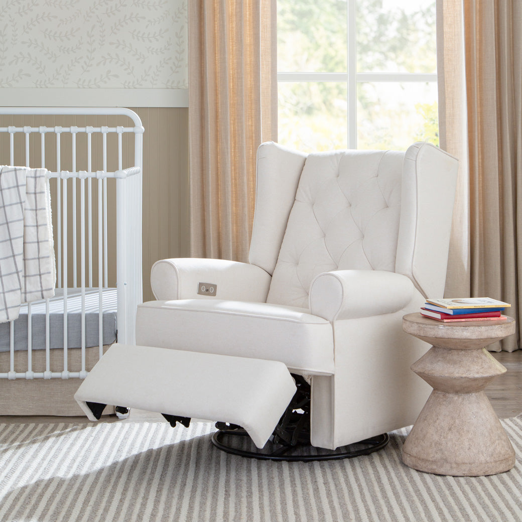 Namesake's Harbour Power Recliner with the footrest of next to a crib in -- Color_Performance Cream Eco-Weave