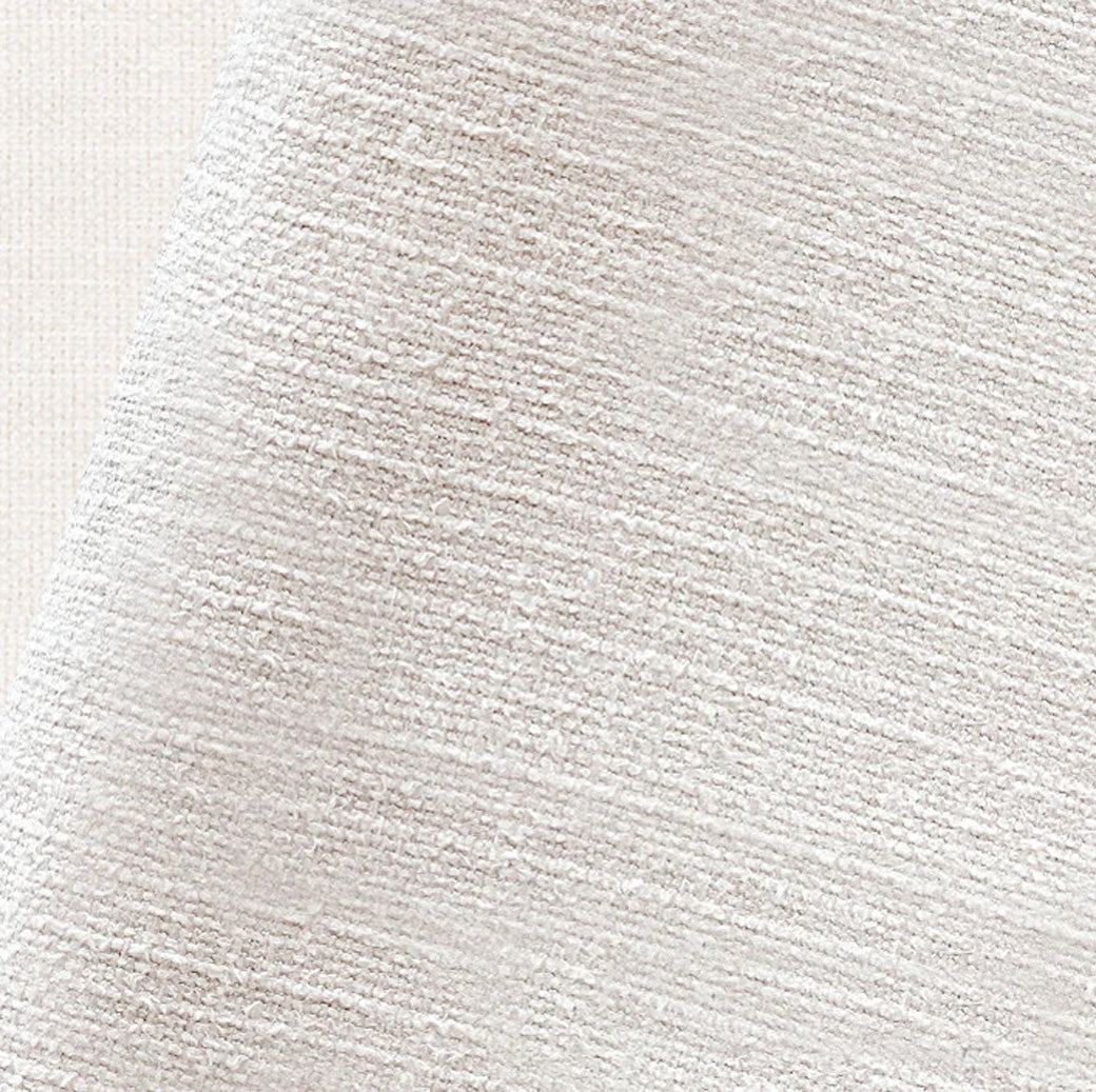 Close-up of beige textured fabric upholstery with soft boucle-like fibers