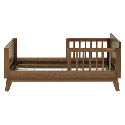 Side view of assembled Junior Bed Conversion Kit For Hudson And Scoot Crib without a mattress in -- Color_Natural Walnut