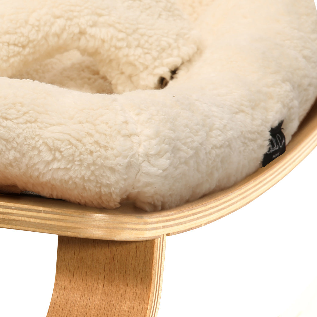 Up close of the front edge on the Charlie Crane LEVO Baby Rocker in -- Color_Fur Milk _ Beech
