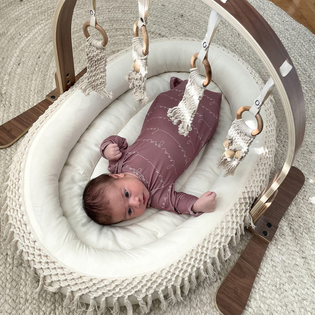 Top view of baby laying down looking at Finn and Emma Play Gym in -- Color_Dark _ Macrame