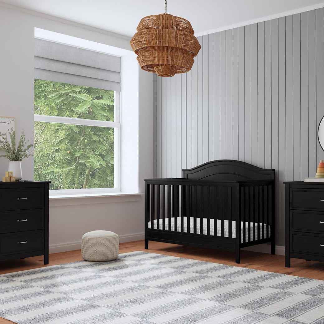 The DaVinci Charlie 4-in-1 Convertible Crib next to a window in -- Color_Ebony