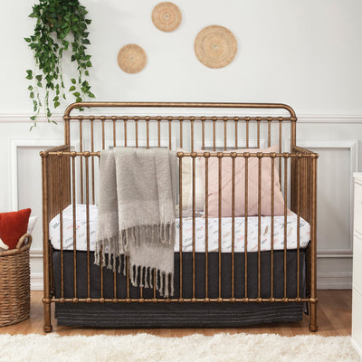 Namesake's Winston 4 in 1 Convertible Crib with a blanket over the rail  in -- Color_Vintage Gold