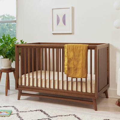 Babyletto's Peggy 3-in-1 Convertible Crib with blanket over the rail  in -- Color_Natural Walnut