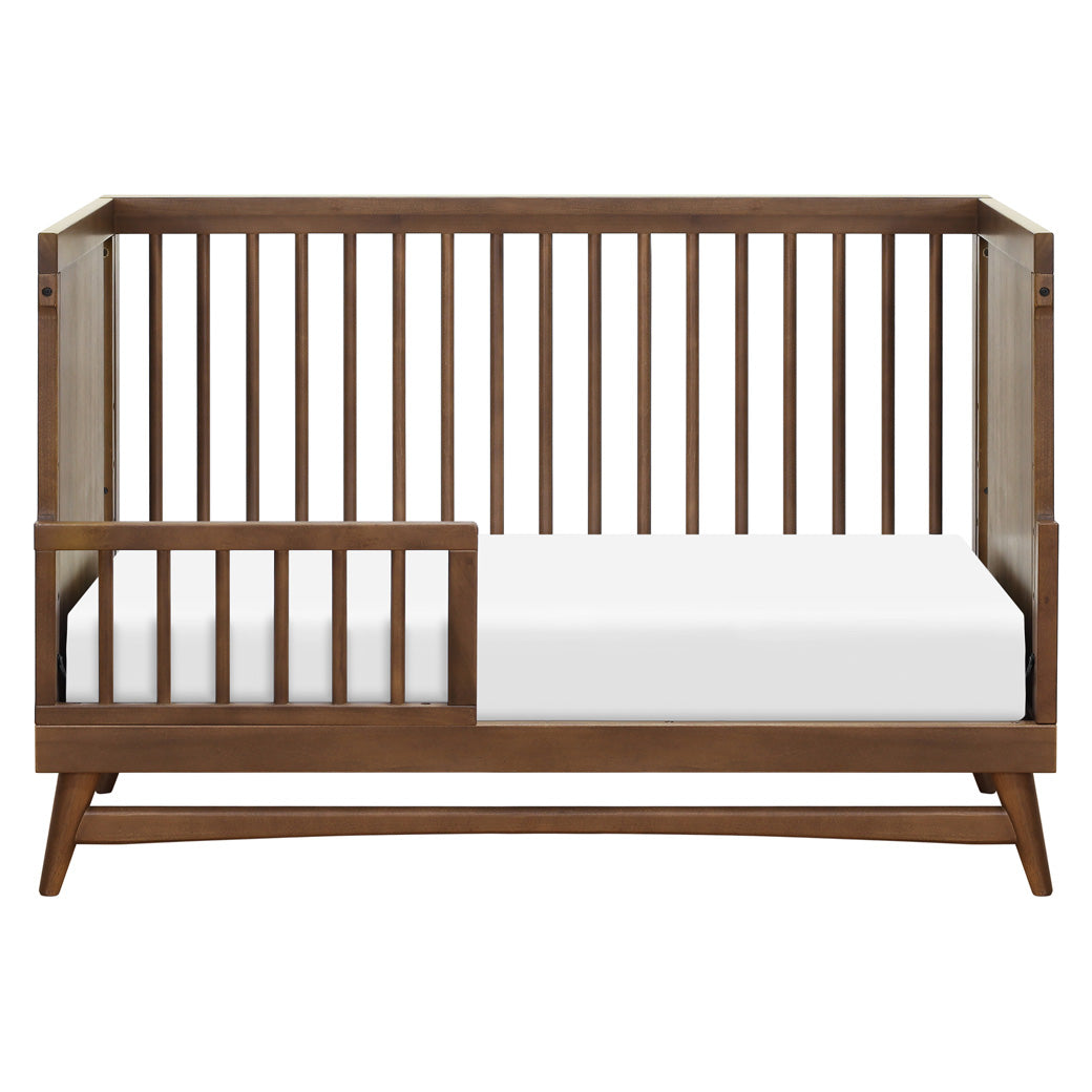 Front view of Babyletto's Peggy 3-in-1 Convertible Crib as toddler bed in -- Color_Natural Walnut