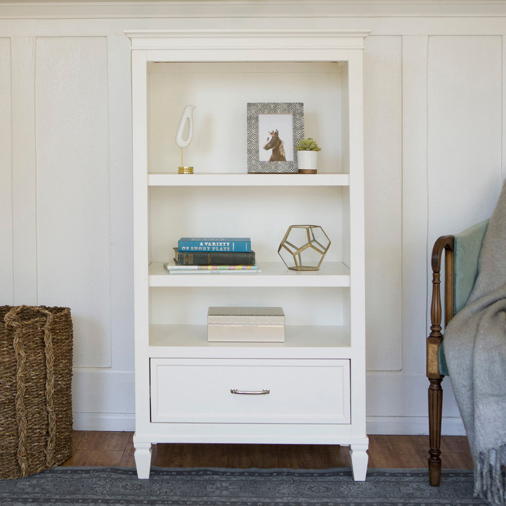 Namesake's Darlington Bookcase in Warm White in a room next to a basket and chair