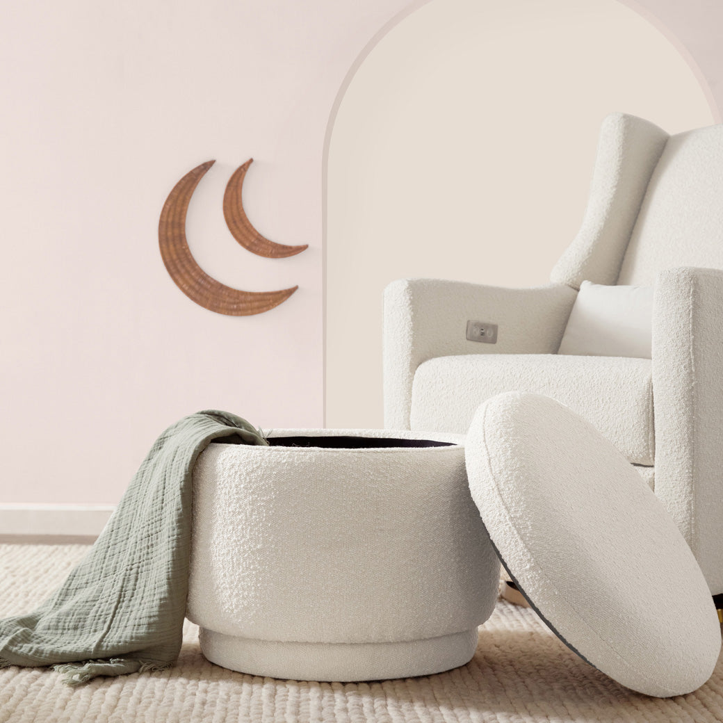 The Babyletto Enoki Storage Ottoman with top off and blanket in it, lifestyle image  in --Color_Ivory Boucle