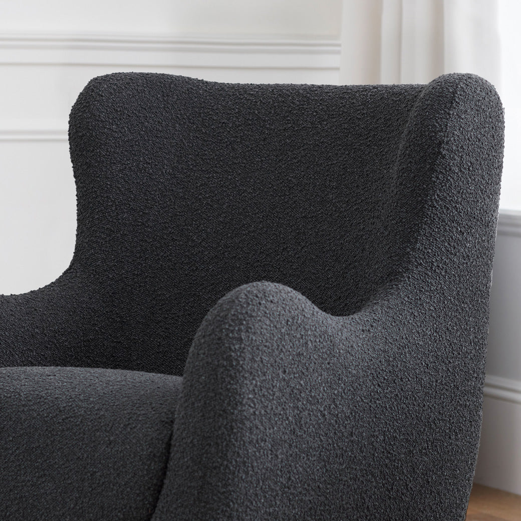 Lifestyle closeup of Nursery Works Solstice Swivel Glider in --Color_Black Boucle with Black Wood Base