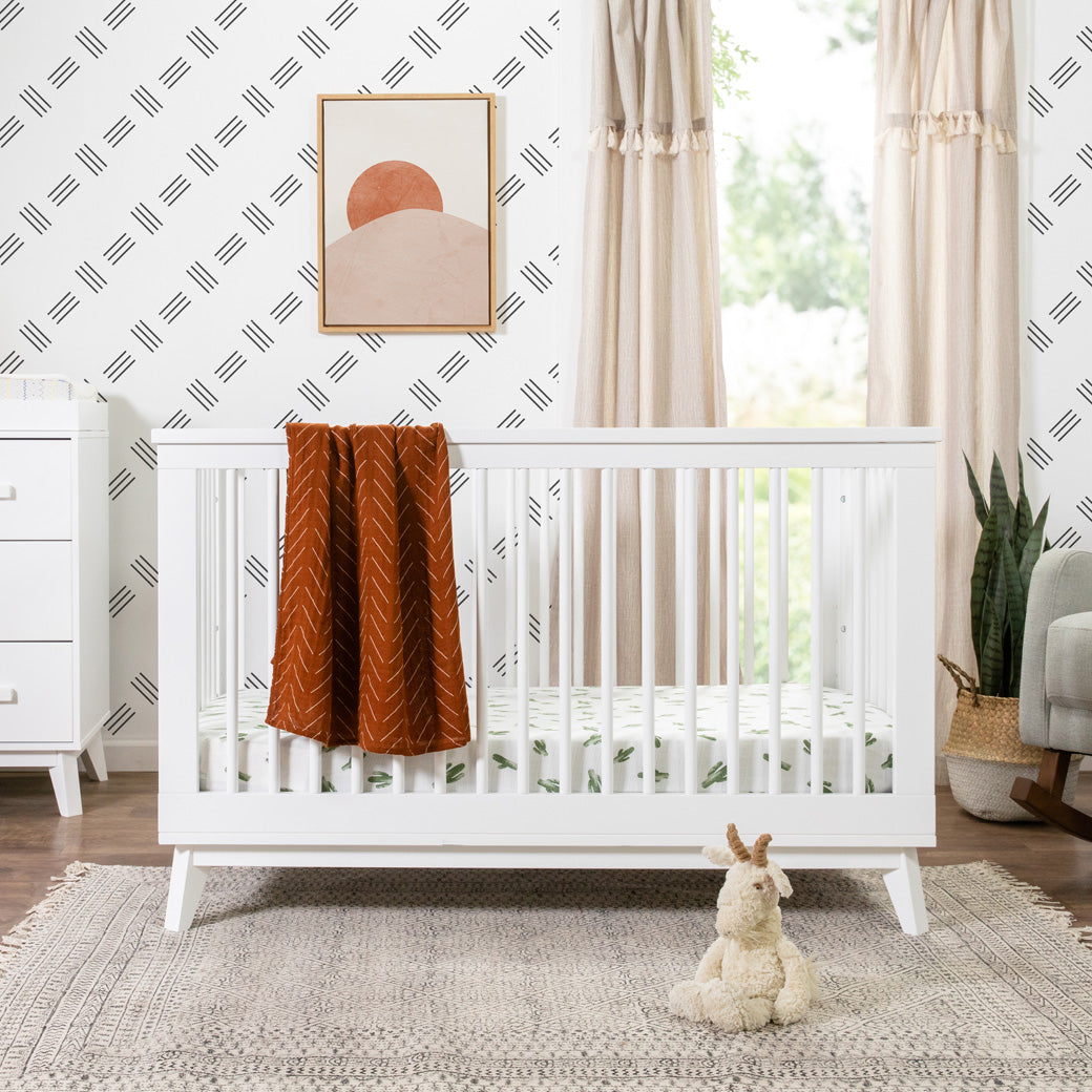 Babyletto's Scoot 3-in-1 Convertible Crib with a blanket over the rail  in -- Color_White