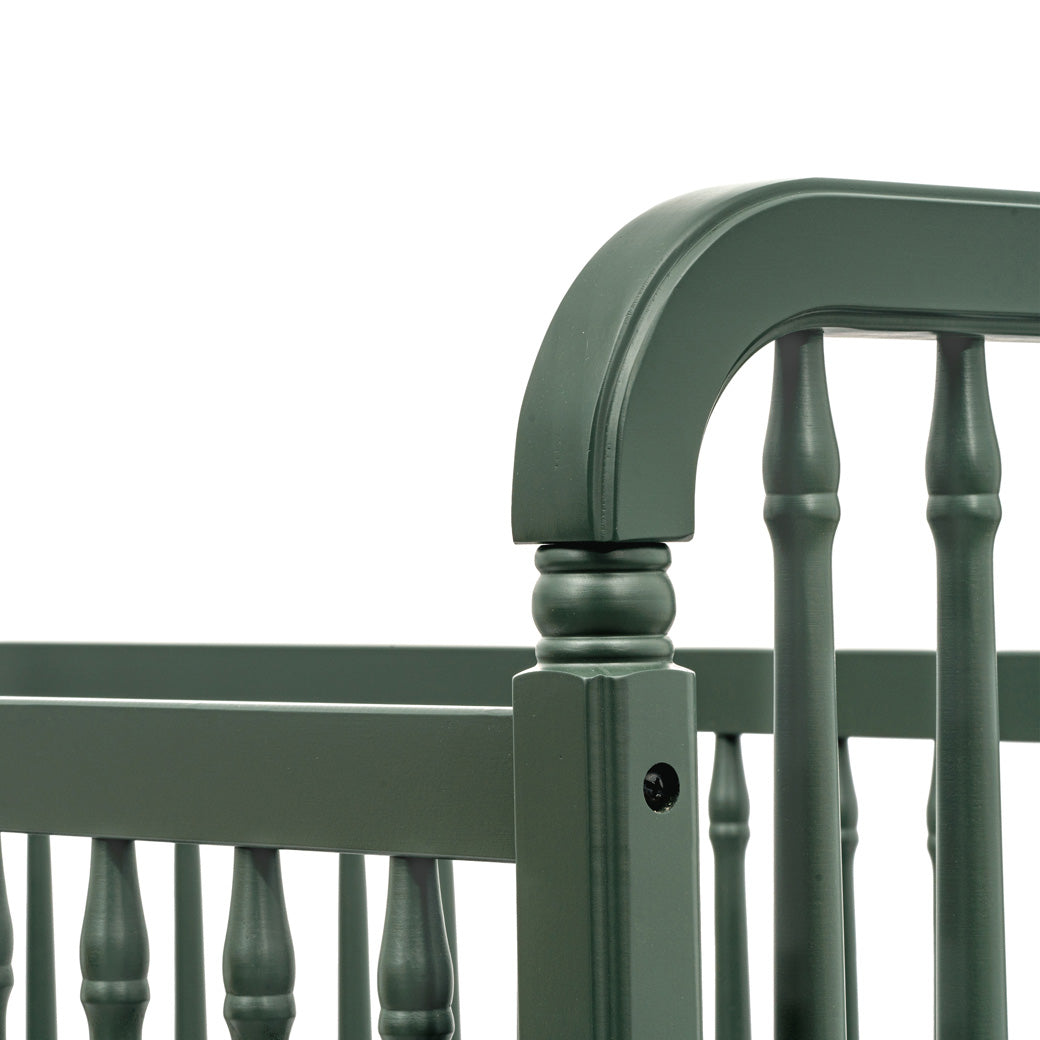 Closeup of the corner of The Namesake Liberty 3-in-1 Convertible Spindle Crib in -- Color_Forest Green