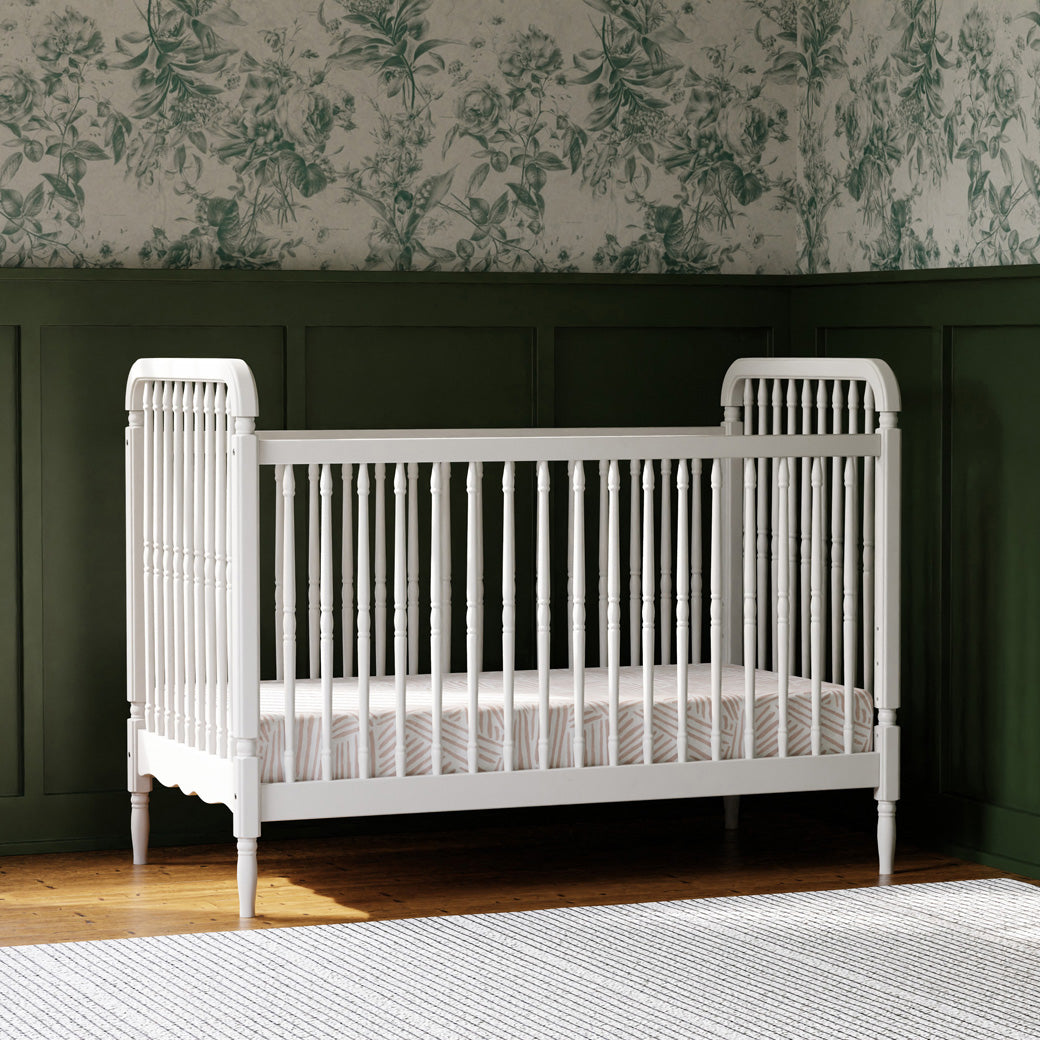 Lifestyle view of The Namesake Liberty 3-in-1 Convertible Spindle Crib in a green room in -- Color_Warm White