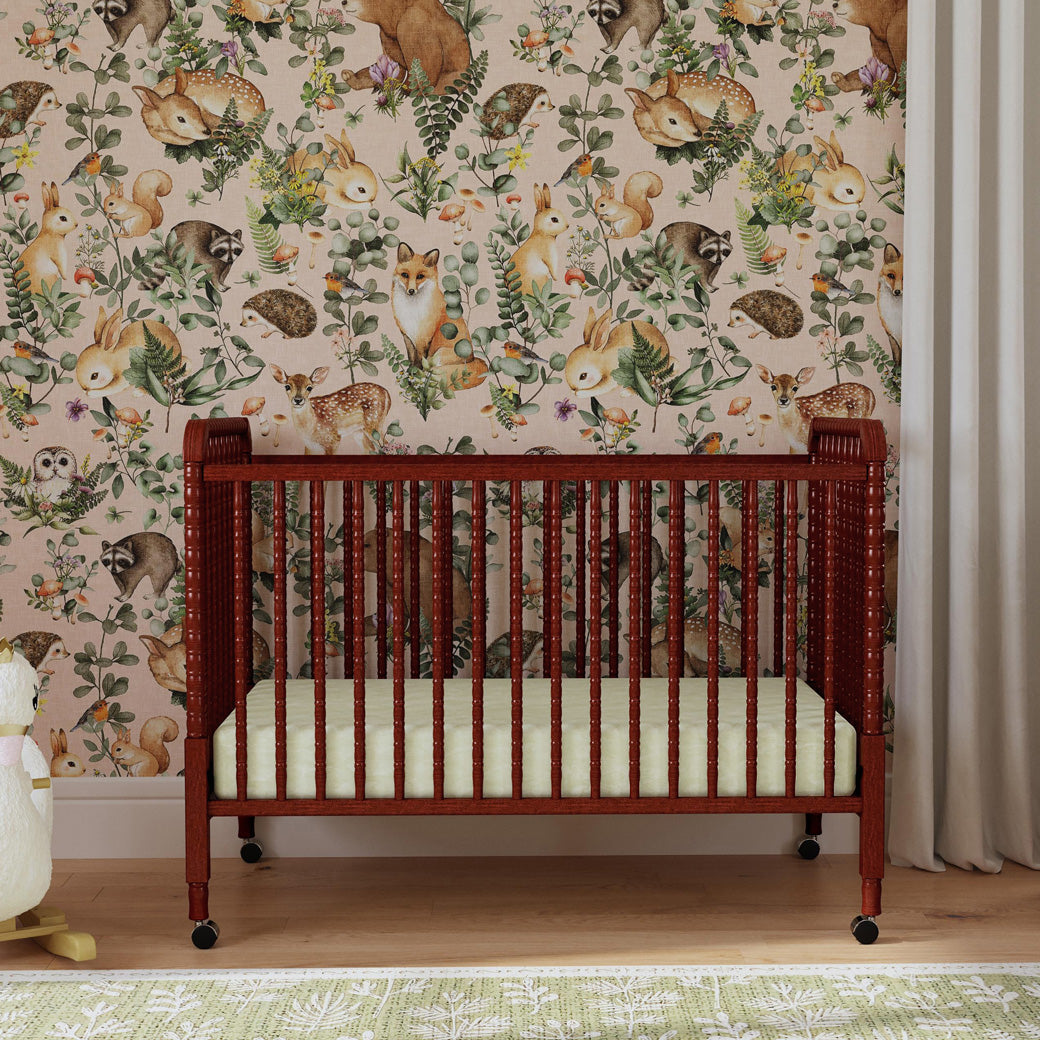Lifestyle front view of the DaVinci’s Jenny Lind Crib in a nature themed room in -- Color_Rich Cherry