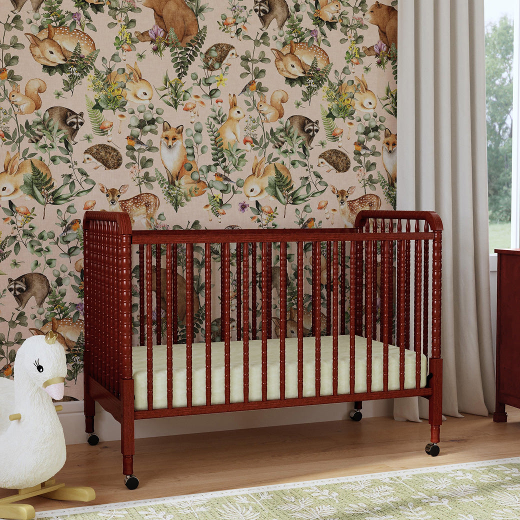 Lifestyle corner view of the DaVinci’s Jenny Lind Crib in a nature themed room in -- Color_Rich Cherry