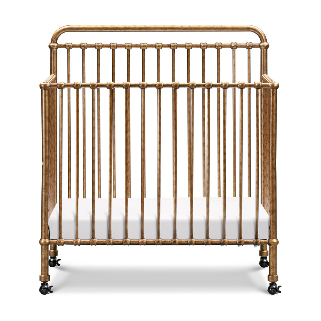Front view of Namesake's Winston 4-in-1 Convertible Mini Crib in -- Color_Vintage Gold