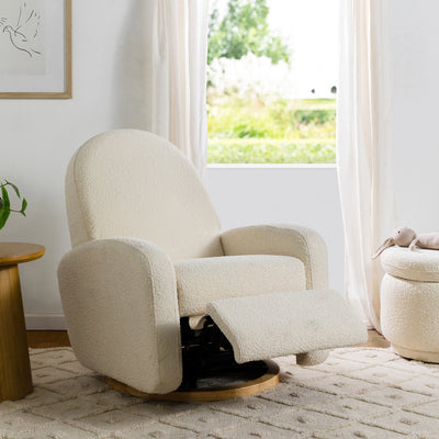 The reclined Babyletto Nami Glider Recliner in a room next to a window in -- Color_Ivory Boucle With Light Wood Base