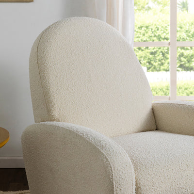 Closeup of the armrest and backrest of The Babyletto Nami Glider Recliner in -- Color_Ivory Boucle With Light Wood Base