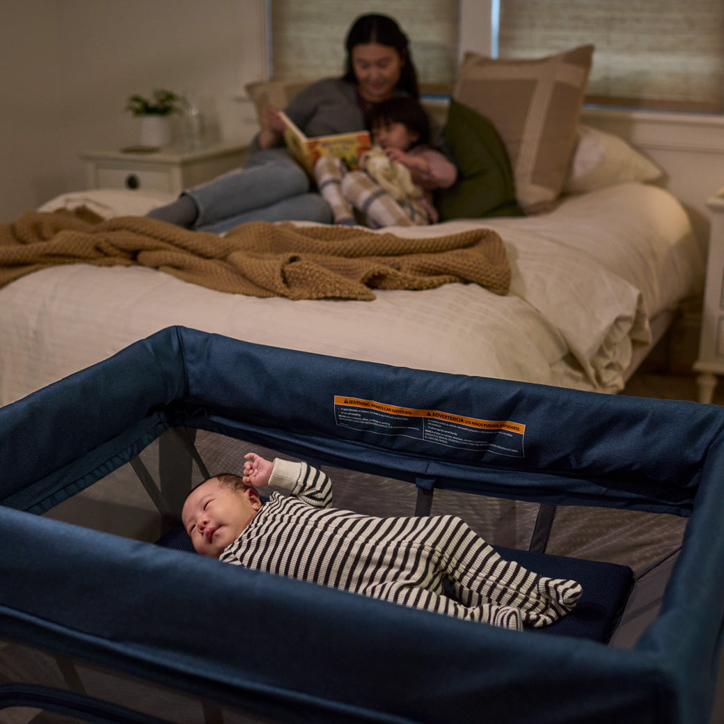 Baby sleeping in UPPAbaby REMI travel crib's bassinet attachment -- Lifestyle