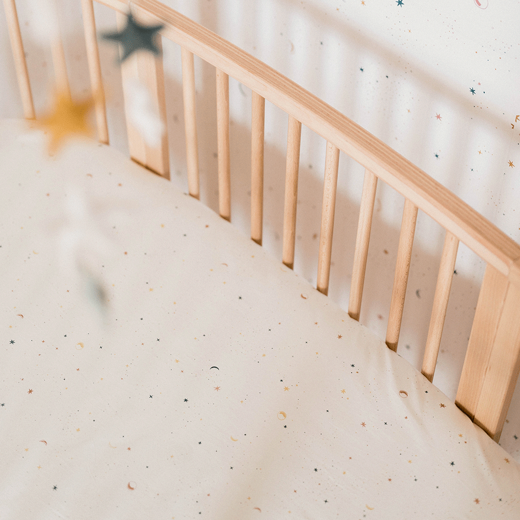 Top view of a crib equipped with a Stokke's Sleepi V3 Fitted Sheet By Pehr in -- Color_Celestial