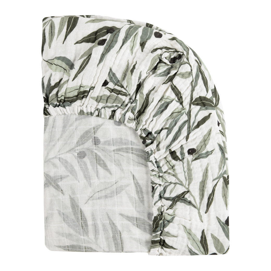 Back corner view of Babyletto's All-Stages Midi Crib Sheet In GOTS Certified Organic Muslin Cotton in -- Color_Olive Branches