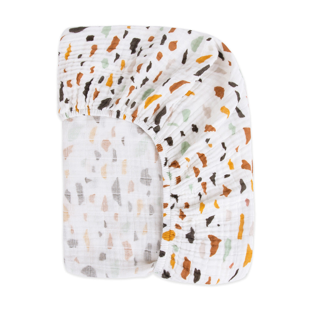 Back view of the corner of the Babyletto's Crib Sheet in GOTS Certified Organic Muslin Cotton in -- Color_Terrazzo