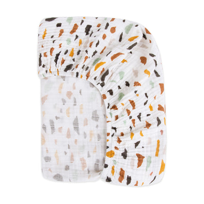 Back view of the corner of the Babyletto's Crib Sheet in GOTS Certified Organic Muslin Cotton in -- Color_Terrazzo