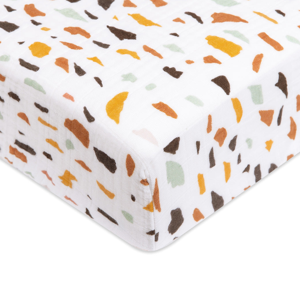 A closeup of the Babyletto's Crib Sheet in GOTS Certified Organic Muslin Cotton corner in -- Color_Terrazzo