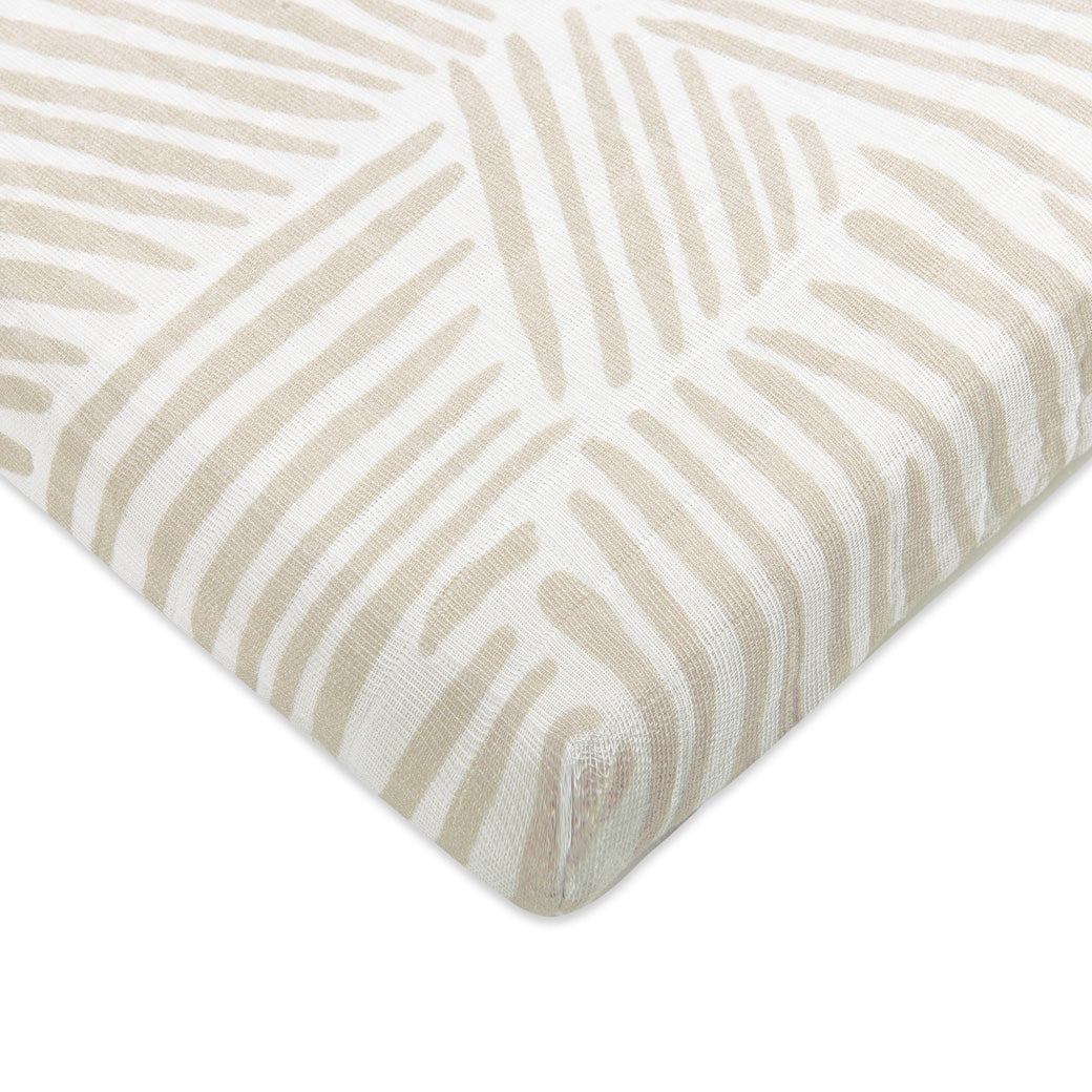 Corner view of Babyletto's All-Stages Midi Crib Sheet In GOTS Certified Organic Muslin Cotton in -- Color_Oat Stripe