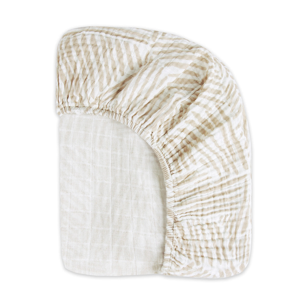 Back view of the corner of the Babyletto's Crib Sheet in GOTS Certified Organic Muslin Cotton in -- Color_Oat Stripe