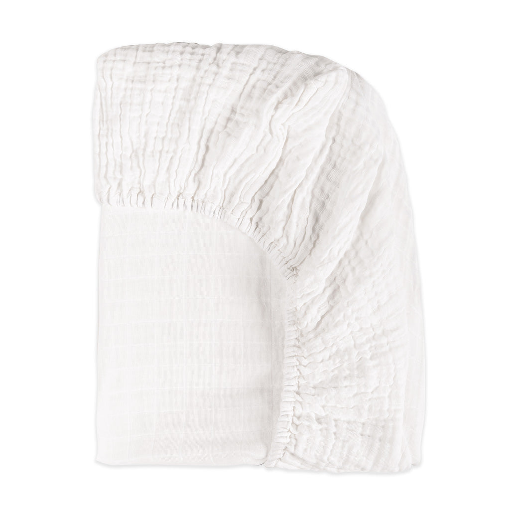Back corner view of Babyletto's All-Stages Midi Crib Sheet In GOTS Certified Organic Muslin Cotton in -- Color_White