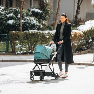 Young woman going for a walk with her newborn in the Thule Shine Stroller in -- Color_Mallard Green