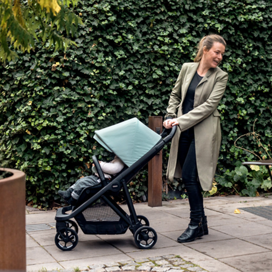 Mother is smiling with her baby in the Thule Shine Stroller in -- Color_Alaska