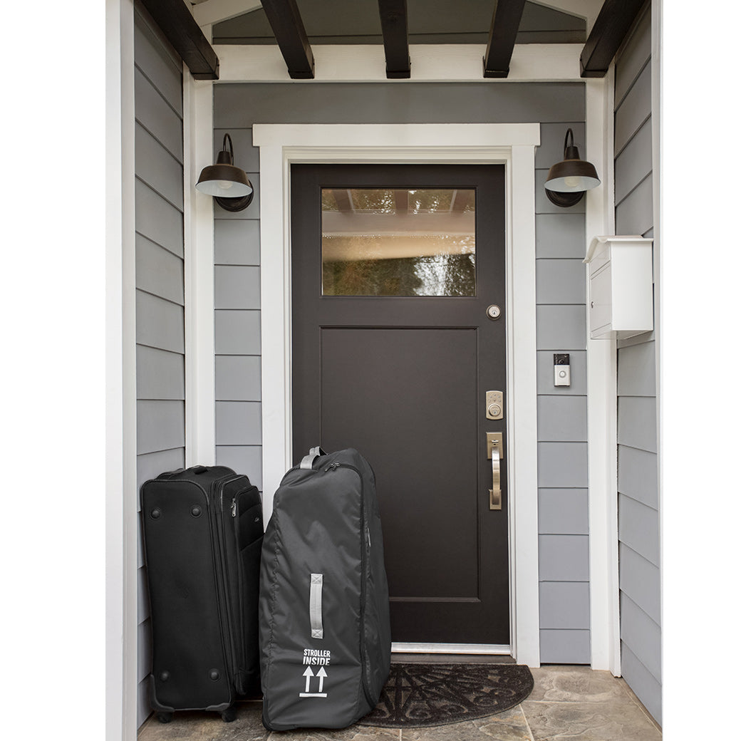 The UPPAbaby VISTA V2 Stroller travel bag in front of a house door -- Lifestyle