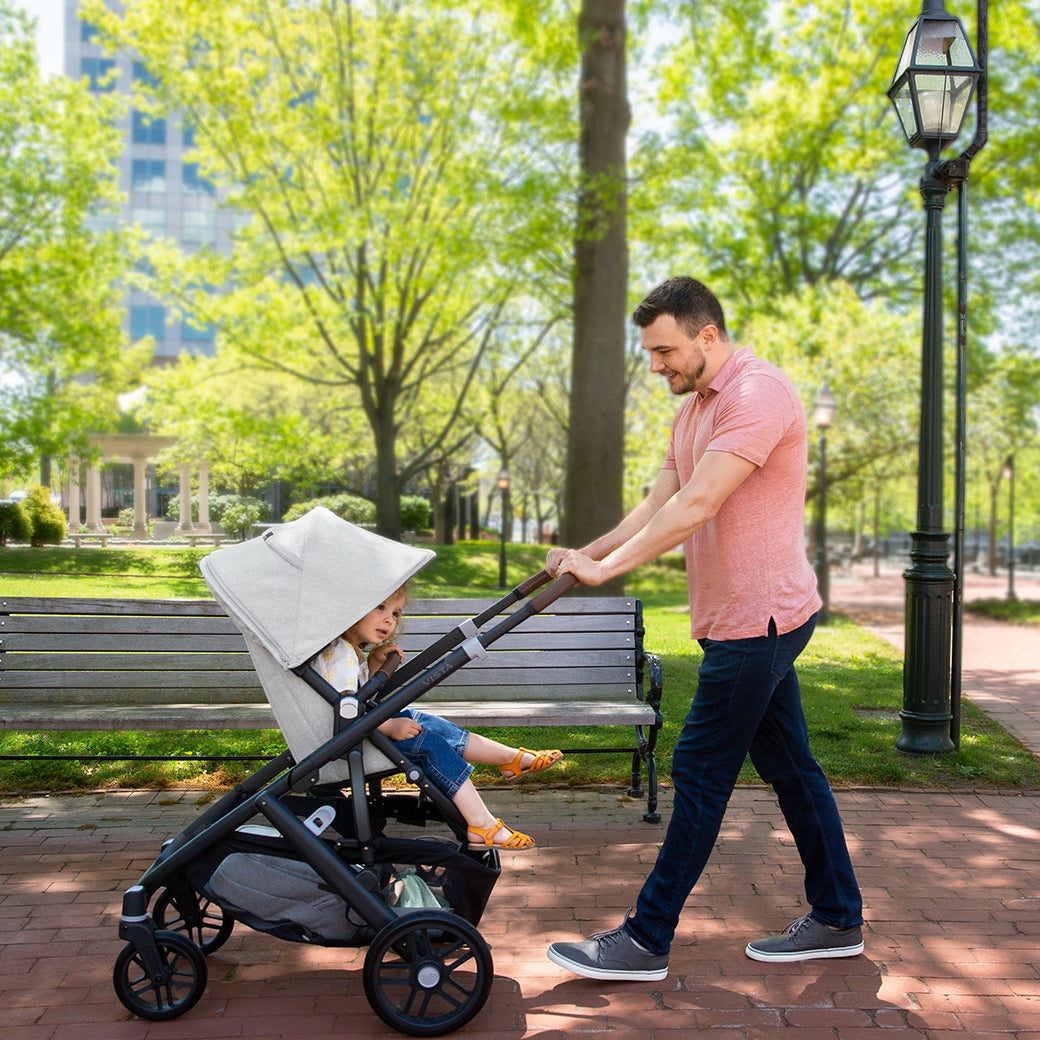 Man pushing vista v2 stroller while walking in the park -- Color_Anthony