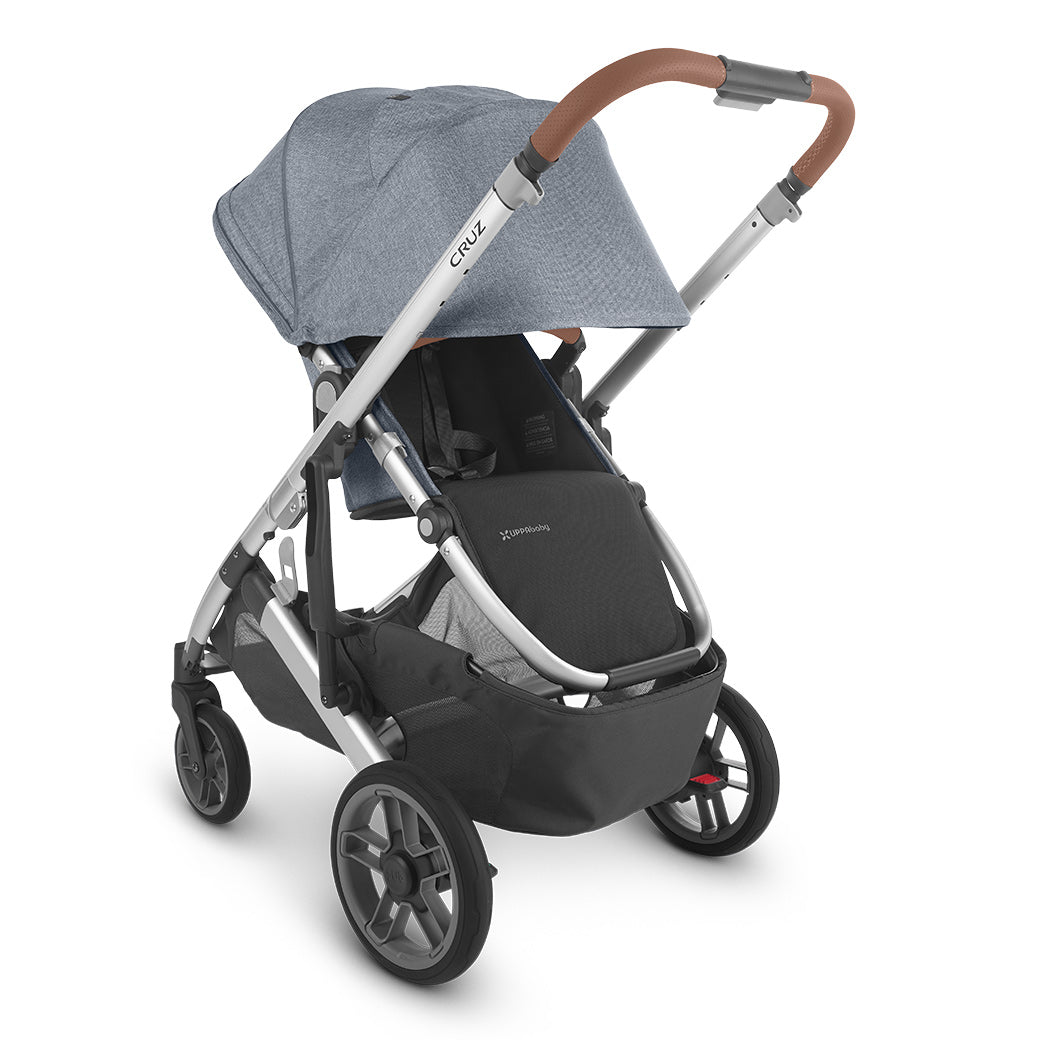 Slightly left rear-facing view of parent-facing configuration of UPPAbaby CRUZ V2 Stroller with sun shade fully extended in bluish gray and black -- Color_Gregory