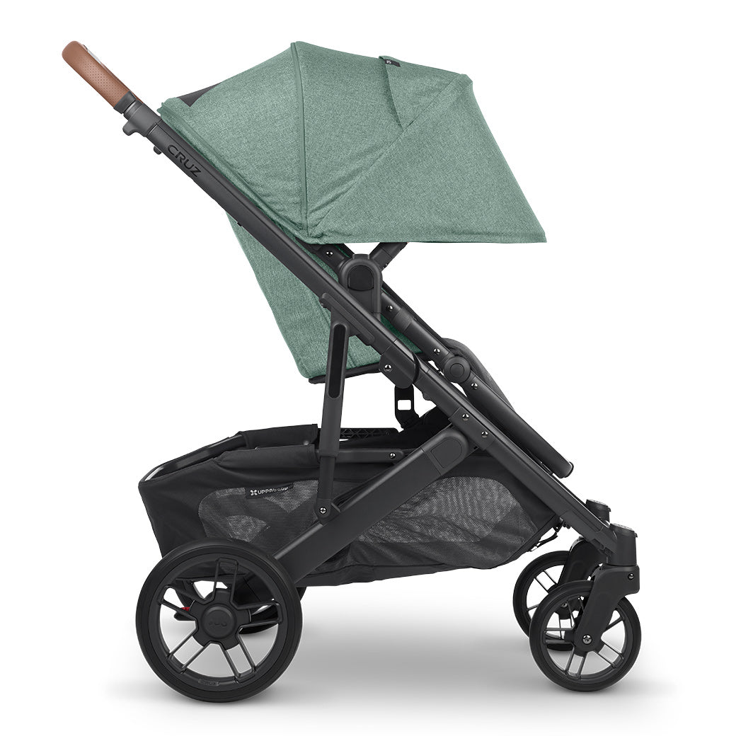 Side view of UPPAbaby CRUZ V2 Stroller with both baskets facing right in a green color -- Color_Gwen