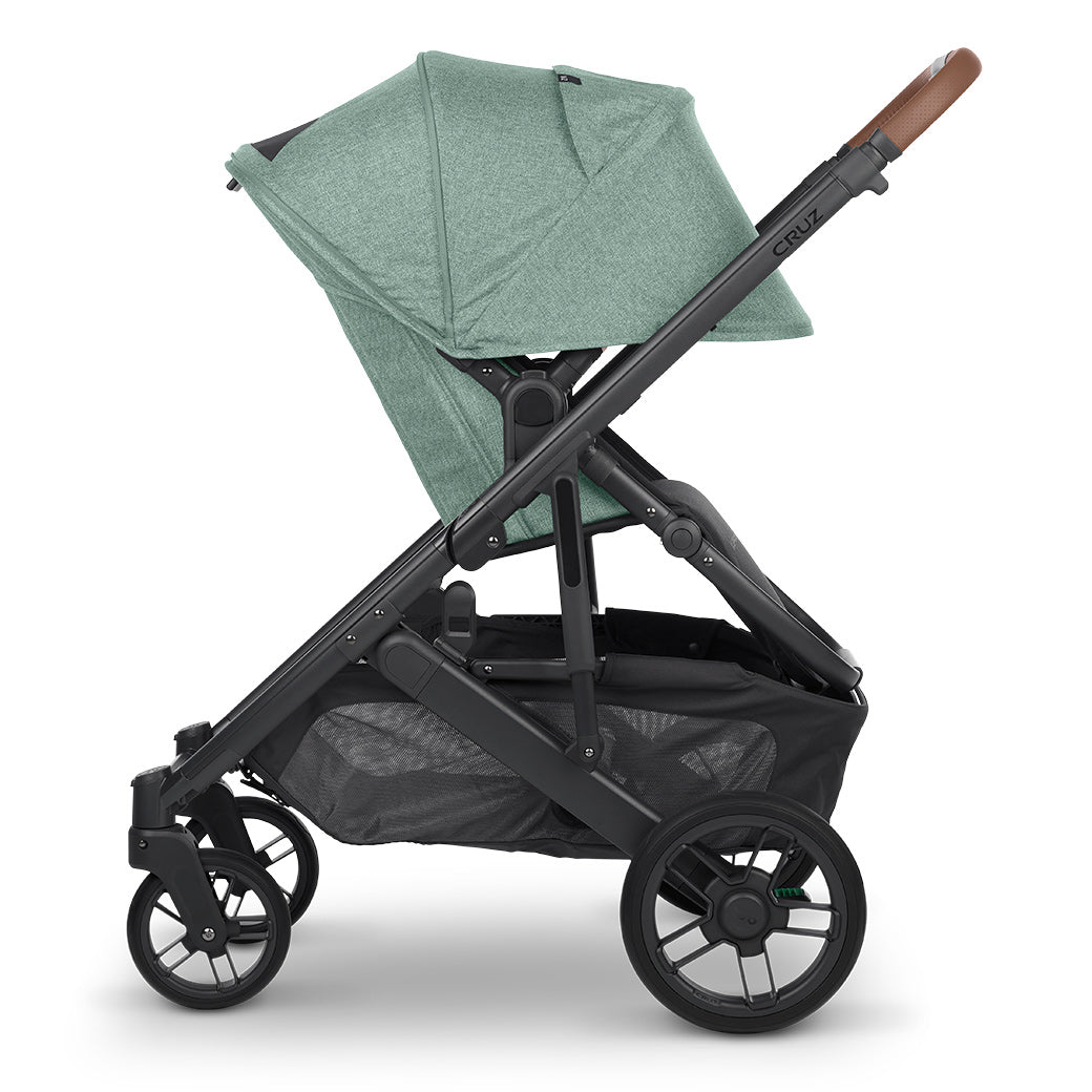 Side view of UPPAbaby CRUZ V2 Stroller with both baskets facing right in a green color -- Color_Gwen