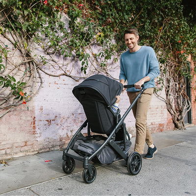 Dad pushing a baby in the UPPAbaby Cruz V2 Stroller in -- Color_Jake