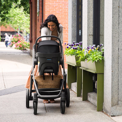 Mom going down the street with baby in UPPAbaby VISTA V2 Travel System in -- Color_Jake